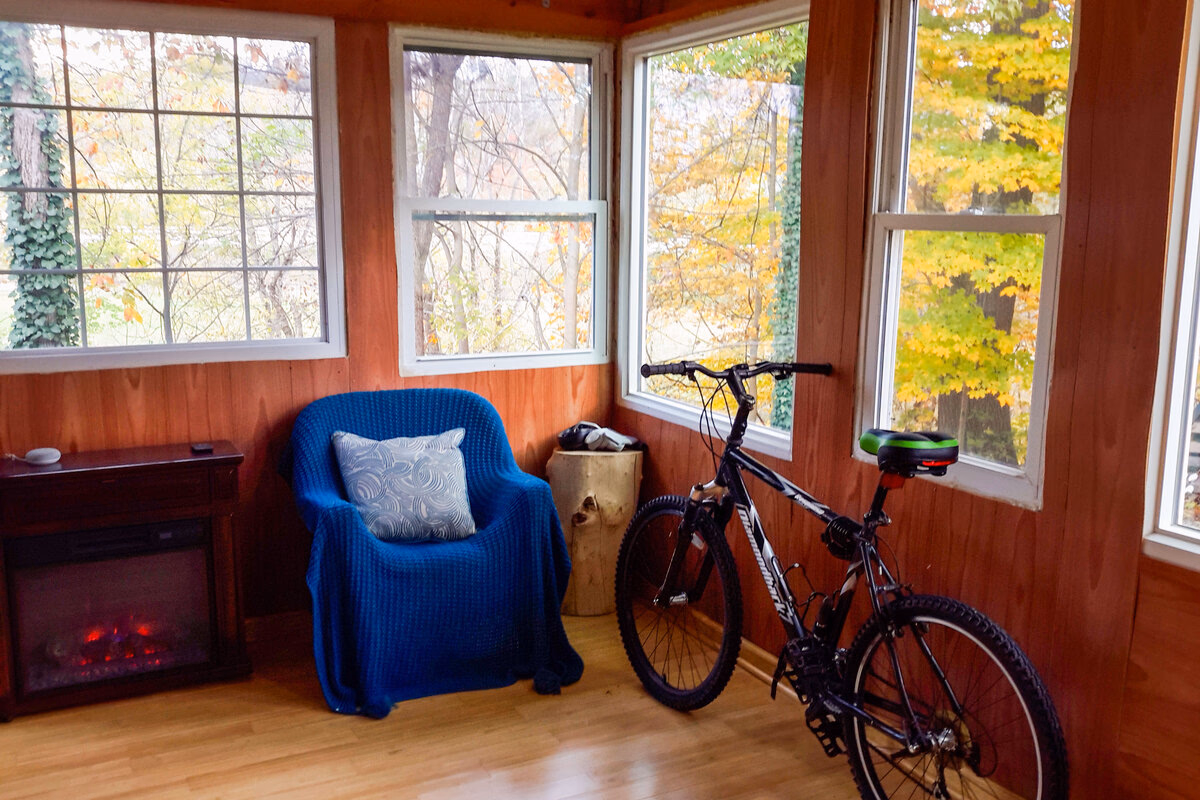 Screened porch with a bicycle and chair beside a SILK Homes property